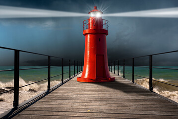 Old red lighthouse with light beams on a wooden pier with rough sea, storm clouds (cumulonimbus)...