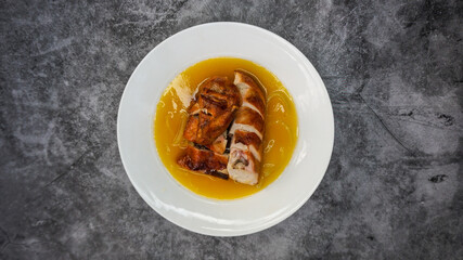 Cantonese-style chicken with sauce served in a plate placed on the table