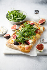 Homemade pizza with figs and arugula