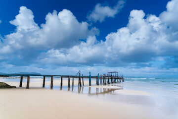 Wooden pier bridge Extending into the Sea, Embracing Thailand's Eastern Island's Rocky Shores as day time.