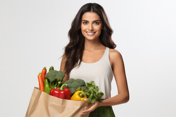 Indian woman holding full of vegetables bag on white background.