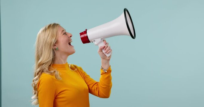 Megaphone, news and woman shouting in studio for sale, information or announcement on blue background. Speaker, noise and female model screaming with bullhorn for vote, motivation or coming soon deal
