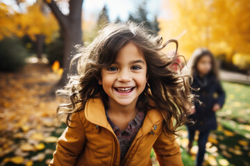 Fototapeta premium Little girl smile playing at park in autumn morning, yellow jacket