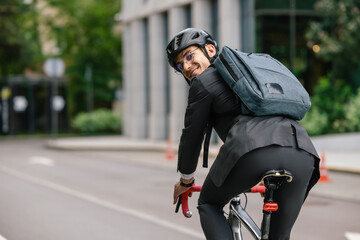 Young man in black suit riding a bike