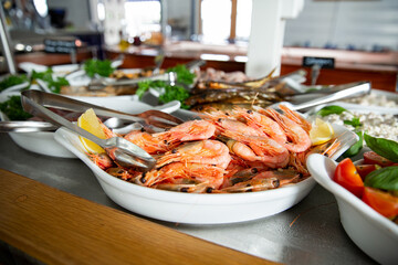 delicious shrimp on a serving plate on the buffet table in the restorant. Seafood buffet lunch in a cafe