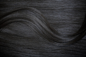 Brunette or black hair. Female long dark hair in black. Beautifully laid curls. Closeup texture in...