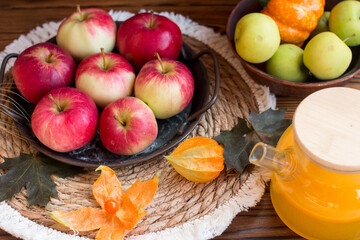 Autumn still life with pumpkin, physalis and spikelets. Concept of a village on a wooden background with apples and maple leaves