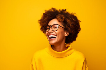 Obraz premium Woman laughs and types on smartphone in studio, reading funny social media posts and mobile news on yellow background. happy african model