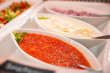 Delicious red caviar on a serving plate on the buffet table in the restorant. Seafood buffet lunch in a cafe in Finland