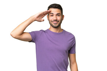 Young handsome caucasian man over isolated background saluting with hand with happy expression