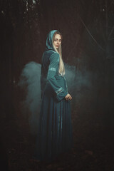 Beautiful woman in misty dark woods - 647182471