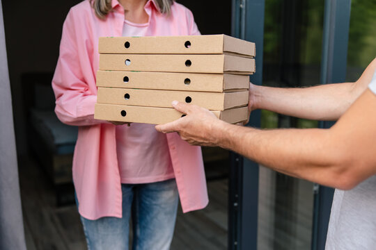 Deliver man handling box of pizza give to female costumer.