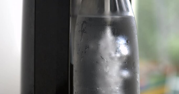 Adding sprinkling water into bottle, close-up of refreshing beverage, sprinkle water machine