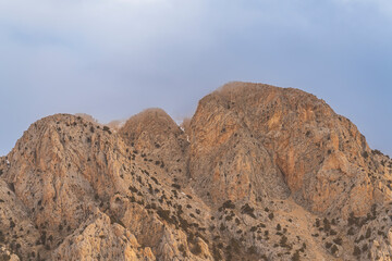 barren mountains with clouds on top