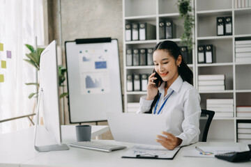 Happy asian business woman have the joy of talking on the smartphone, tablet and laptopon the office ..