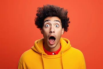 Deurstickers young man expressing surprise and shock emotion with his mouth open and wide open eyes. isolated on color background © wolfhound911