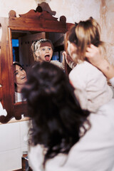 oyful Mirror Play: Mother-Daughter Bonding in a Cozy Rustic Bathroom.