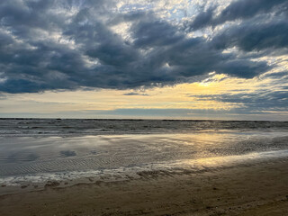 Sunrise among the clouds over the sea coast