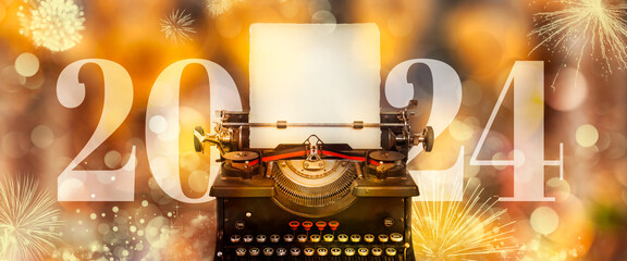 2024 New Year announcement with typewriter and defocused golden background and fireworks