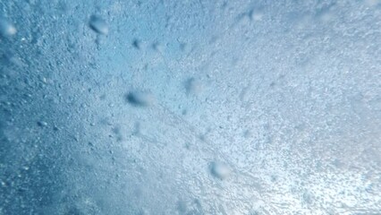 Slow motion ascent of air bubbles from the sea bottom to the water's surface, enhanced by a diver's exhalation. An ideal choice for creating an abstract and tranquil natural backdrop.