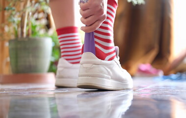 Person carries spoon with and puts on sports shoes. Facilities for putting on shoes concept