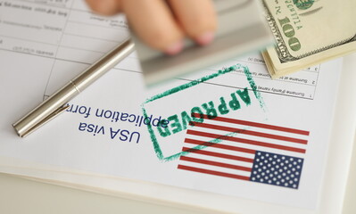 Close-up of green approved stamp on document, visa application form, hand stamping approved on...