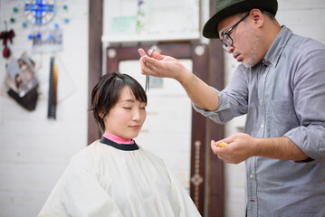 美容院で前髪をカットしてもらう女性