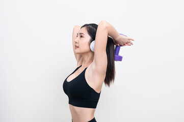 Obraz premium Asian woman wearing black workout clothes with smiling face Exercising with purple dumbbells and cheerful music in headphones against a white or isolated background.