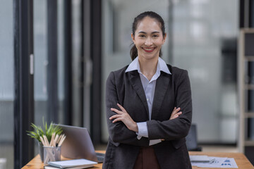 Portrait of successful business asian women arms crossed and smile dressed casually with happy and self-confident positive expression isolated over office background
