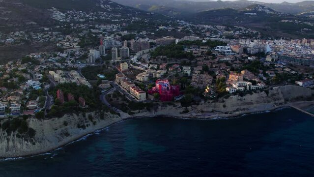 Aerial drone footage of bright modern architecture apartment building by Ricardo Bofill in Calpe, Spain. Costa Blanca mediterranean coast and summer vacation homes and villas