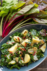 Blitva dish made with boiled potatoes, Swiss chard, garlic and olive oil. Fresh beet leaves on wooden rustic table.