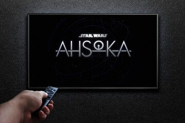 Obraz premium Ahsoka trailer or movie on TV screen. Man turns on TV with remote control. Astana, Kazakhstan - September 8, 2023.