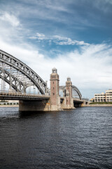 An ancient metal and stone bridge with towers over a wide river.
