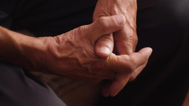 crossed arms of a pensive pensioner, real people of retirement age, wrinkled hands of an elderly man 80 years old