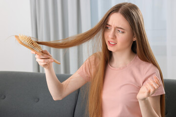 Upset woman brushing her hair at home. Alopecia problem