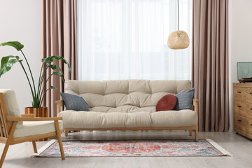 Beautiful rug, furniture and plant near window indoors