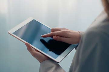 Closeup view of woman using modern tablet on blurred background