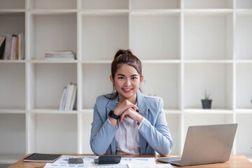 Asian businesswoman use laptop computer in office The Internal Revenue Service audit document balance calculation report is being prepared.