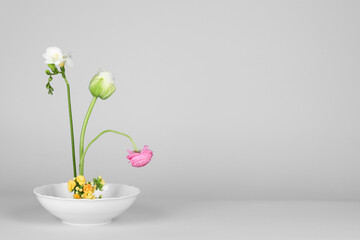 Stylish ikebana as house decor. Beautiful fresh flowers on white background, space for text