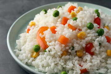 Delicious rice with vegetables on grey table, closeup
