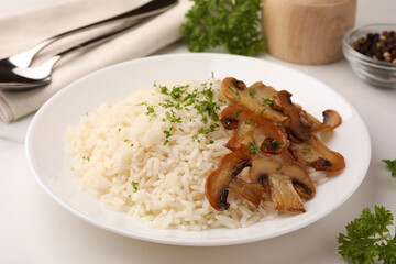 Delicious rice with parsley and mushrooms on white table