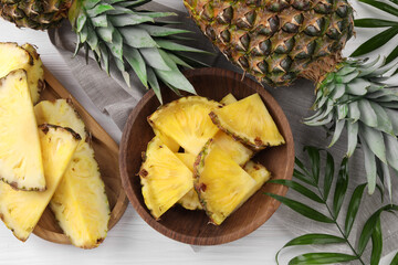 Pieces of tasty ripe pineapple on white wooden table, flat lay