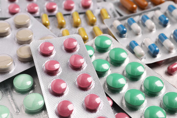 Many different pills in blisters as background, closeup