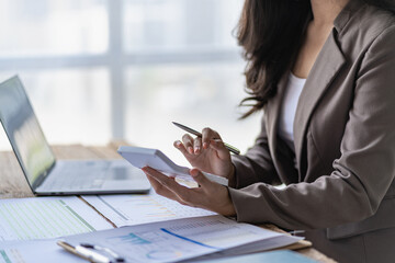 Accountant analyzes invoice investment chart and presses calculator button over document Accounting clerk, bank consultant and auditor in office close-up photo