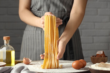Woman making homemade pasta at table, closeup