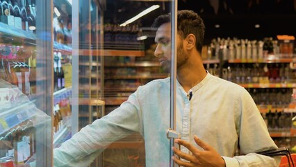 Indian man doing shopping at market while buying cold drink