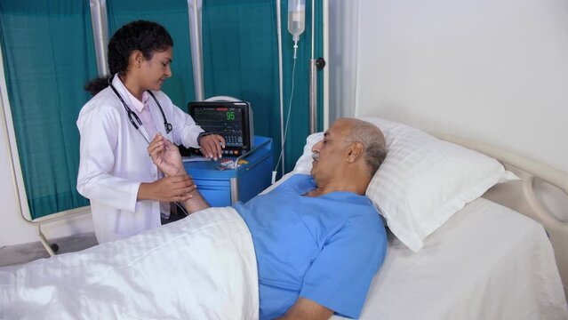 An aged patient wearing blue hospital clothes and a cannula is admitted to the hospital - old age  sick man  lonely patient. A middle-aged female nurse is checking the pulse rate of an elderly man ...
