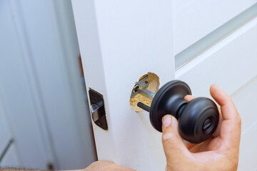 Worker successfully installs lock on new interior door