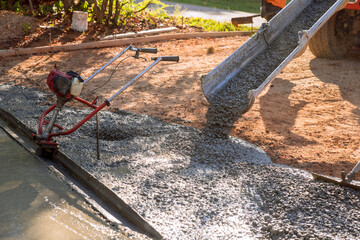 In front of home mixer truck pours wet cement ready mixed concrete for driveway