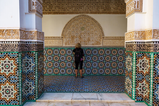 Morocco. Marrakesh. Madrasa Ben Youssef. The largest and most important madrassah in Morocco. A woman tourist look at the koranic writing